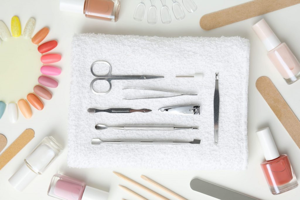 Kit profesional con herramientas de manicura y pedicura sobre toalla blanca, ideal para el cuidado de uñas